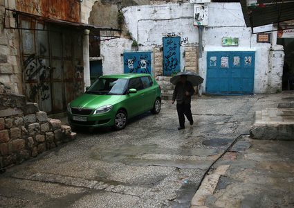 فلسطينيون يسيرون في شارع غمرته المياه في يوم ممطر في المدينة القديمة لمدينة نابلس بالضفة الغربية ، في 8 ديسمبر / كانون الأول 2018.