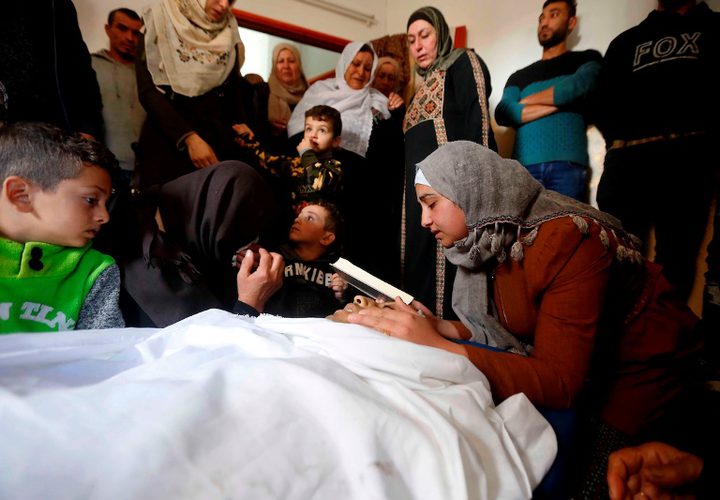 أقارب الفتى الفلسطيني عمر عواد ، 27 عاماً ، الذي قُتل برصاص القوات الإسرائيلية بعد محاولته محاولة هجوم على سيارة قرب نقطة تفتيش حدادا على جسده خلال جنازته في الخليل بالضفة الغربية المحتلة
