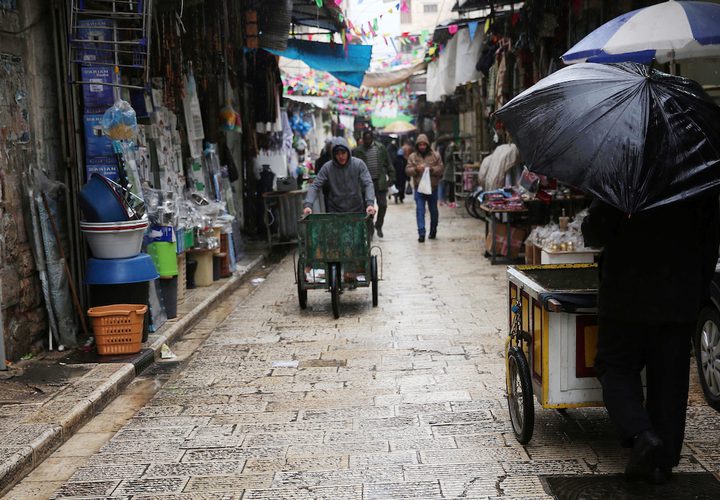 بائع فلسطيني يسير في سوق خلال يوم ممطر ، في مدينة نابلس بالضفة الغربية ، 20 ديسمبر ، 2018.