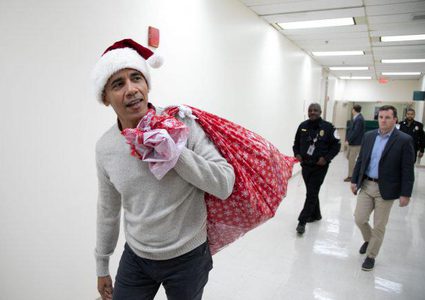 الرئيس الأمريكي السابق باراك أوباما محملا بالهدايا للأطفال