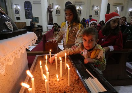 مسيحيون فلسطينيون يحضرون صلاة في الكنيسة اللاتينية عشية الاحتفال بعيد الميلاد ، في مدينة غزة