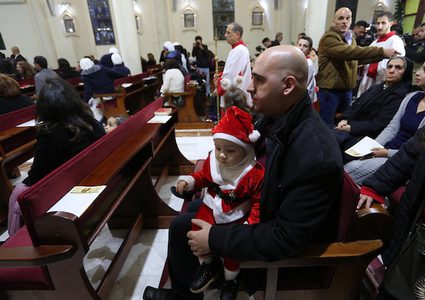 مسيحيون فلسطينيون يحضرون صلاة في الكنيسة اللاتينية عشية الاحتفال بعيد الميلاد ، في مدينة غزة