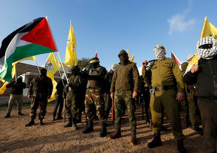 أعضاء فلسطينيون مقنعون في موكب حركة فتح خلال الاحتفال بالذكرى الرابعة والخمسين لتأسيس حركة فتح ، في قرية بني نعيم ، بالقرب من مدينة الخليل في الضفة الغربية ، 5 كانون الثاني / يناير ، 2019.