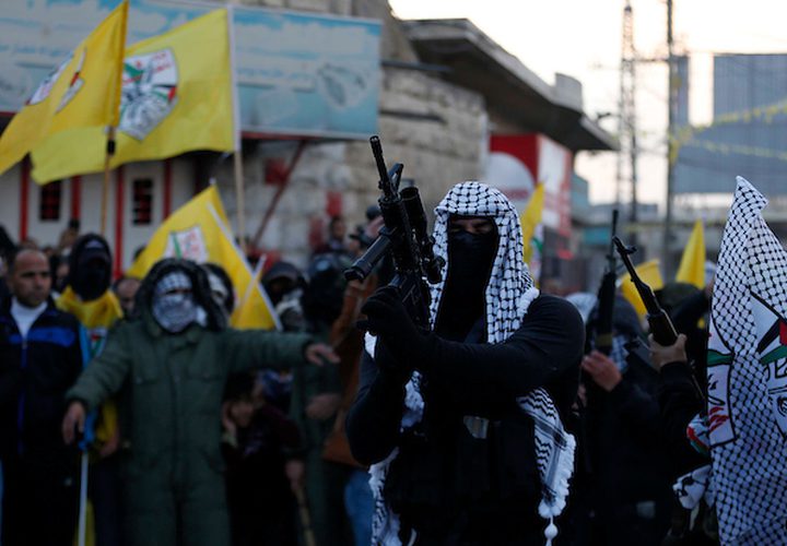 أعضاء في كتائب الأقصى ، الجناح العسكري لحركة فتح خلال الاحتفال بالذكرى الرابعة والخمسين لتأسيس حركة فتح ، في قرية بني نعيم ، قرب مدينة الخليل بالضفة الغربية ، 05 كانون الثاني / يناير ، 2019.