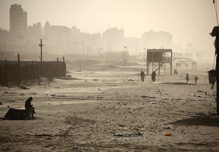 فلسطينيون يسيرون على شاطئ مدينة غزة في يوم عاصف ، في 7 يناير ، 2019.