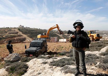 قوات الأمن تقف حراسة بينما تدمر الجرافات الإسرائيلية الأراضي الزراعية في ود السمان بالقرب من مدينة الخليل بالضفة الغربية ، 23 يناير / كانون الثاني 2019. أكدت مصادر محلية أن جرافات الاحتلال اكتسحت حوالي 15 دونماً من الأرض ، وأبقت الجدران في المنطقة. جنوب الخليل.