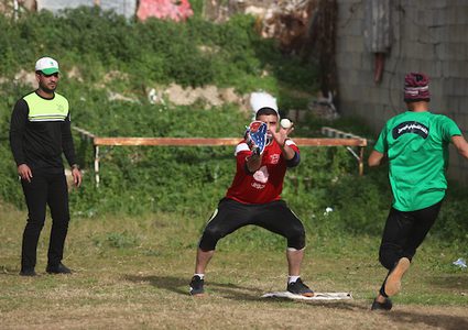 اللاعبون الفلسطينيون من نادي الهلال يتنافسون مع لاعبين فلسطينيين من النادي الأهلي خلال المباراة النهائية للبيسبول في مدينة غزة في 26 يناير 2019.