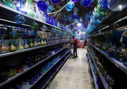 رجل فلسطيني يتفقد قطعة من الزجاج في ورشة زجاجية بالقرب من الحرم الإبراهيمي في مدينة الخليل بالضفة الغربية. A glassblower أو المصمم هو المسؤول عن تصميم وإنتاج وتزيين وإنهاء قطع الزجاج بما في ذلك الزجاج المعماري ، وقطع المعرض ، الهدايا ، والمرايا ، الملون والزجاج والنوافذ وأدوات المائدة.