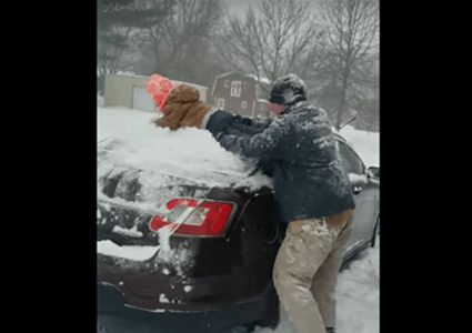 أميركي يمسح الثلج عن سيارته بابنه!
