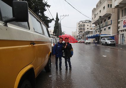 فلسطينيون يسيرون في شارع غمرته المياه في يوم ممطر ، في مدينة غزة ، في 2 مارس ، 2019.