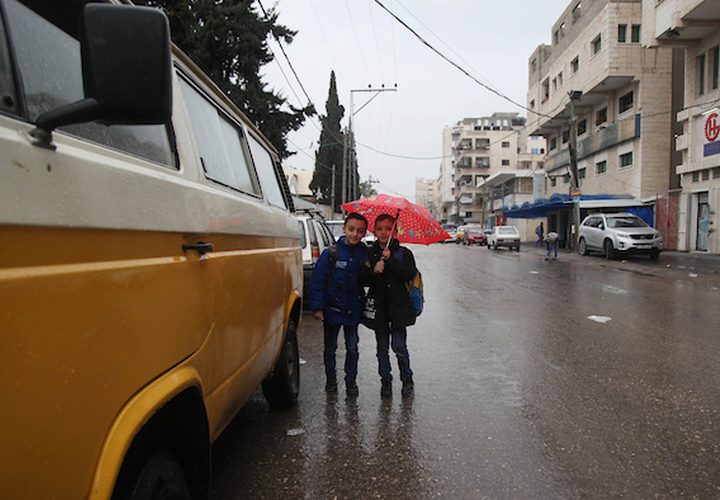 فلسطينيون يسيرون في شارع غمرته المياه في يوم ممطر ، في مدينة غزة ، في 2 مارس ، 2019.