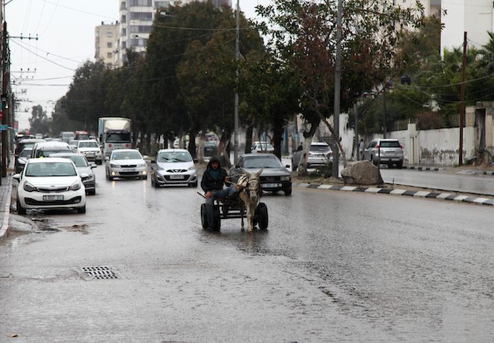 فلسطينيون يسيرون في شارع غمرته المياه في يوم ممطر ، في مدينة غزة ، في 2 مارس ، 2019.