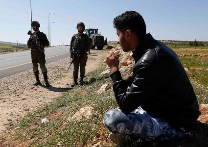 جنود إسرائيليون يقفون حراسة عندما قامت جرافة إسرائيلية بهدم أرض في قرية السميية بالقرب من مدينة الخليل بالضفة الغربية ، في 11 مارس / آذار 2019. دمرت القوات الإسرائيلية ودمرت حطام مدرسة ابتدائية فلسطينية في قرية السميية. جنوب الضفة الغربية المحتلة من الخليل.