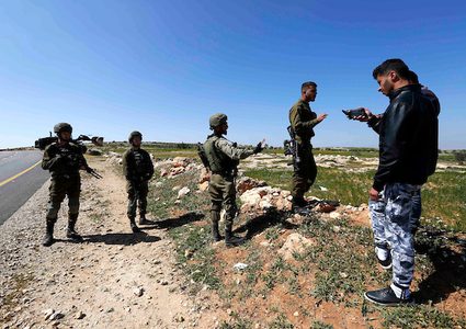 جنود إسرائيليون يقفون حراسة عندما قامت جرافة إسرائيلية بهدم أرض في قرية السميية بالقرب من مدينة الخليل بالضفة الغربية ، في 11 مارس / آذار 2019. دمرت القوات الإسرائيلية ودمرت حطام مدرسة ابتدائية فلسطينية في قرية السميية. جنوب الضفة الغربية المحتلة من الخليل.