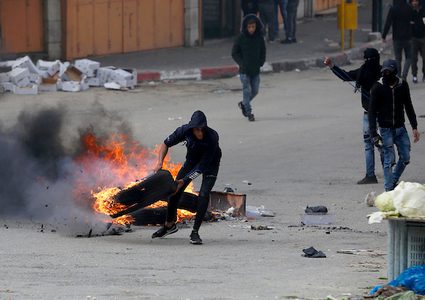 متظاهرون فلسطينيون يرشقون قوات الحتلال الإسرائيلي بالحجارة خلال اشتباكات في مدينة الخليل بالضفة الغربية ، في 15 مارس 2019.