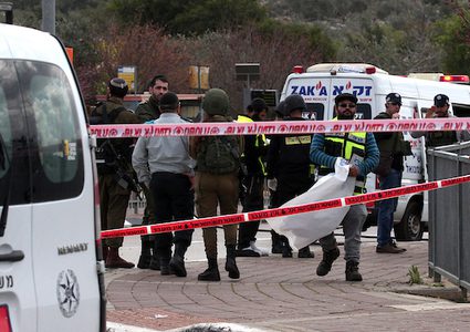 يقف أفراد من قوات الاحتلال الإسرائيلي حراسة بجوار سيارة في موقع الهجوم على مفترق آرييل المؤدي إلى مستوطنة أرييل الإسرائيلية في الضفة الغربية في 17 مارس 2019.