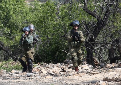 متظاهرون فلسطينيون يلقون الحجارة على قوات الأمن الإسرائيلية خلال اشتباكات في أعقاب مظاهرة أسبوعية ضد مصادرة إسرائيل للأراضي الفلسطينية في قرية كفر قدوم ، بالقرب من مدينة نابلس بالضفة الغربية في 22 مارس 2019.