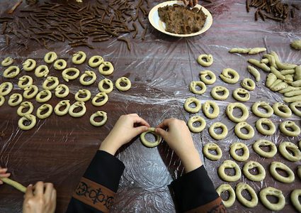 مجموعة من الفتيات في مخيم المغازي وسط القطاع ،يعددن الكعك على الطريقة التقليدية ,,لبيعه للمواطنين في غزة قبل عيد الفطر