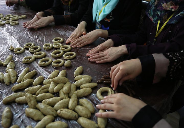 مجموعة من الفتيات في مخيم المغازي وسط القطاع ،يعددن الكعك على الطريقة التقليدية ,,لبيعه للمواطنين في غزة قبل عيد الفطر