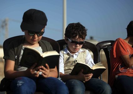 أطفال يقرؤون القرآن الكريم على شاطئ غزة