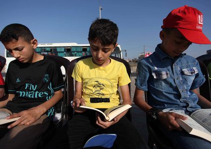 أطفال يقرؤون القرآن الكريم على شاطئ غزة