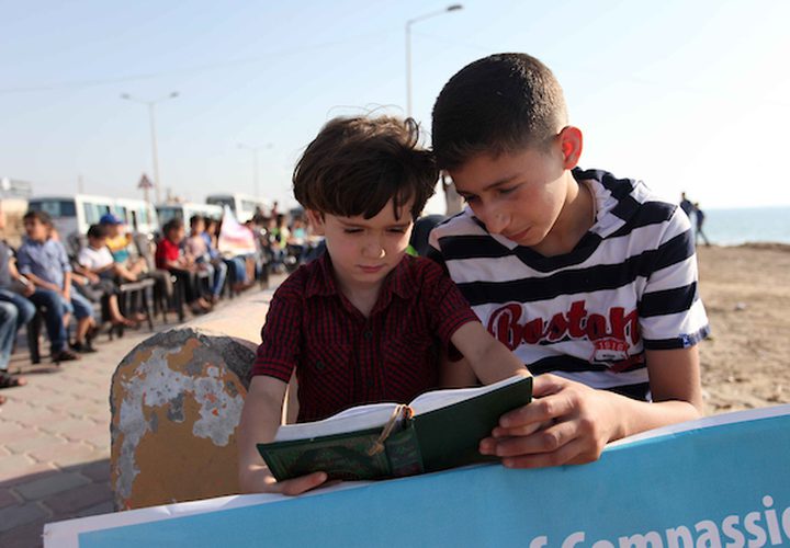 عدد كبير من الأطفال الفلسطينيين يقرأون آيات من القرآن الكريم ، خلال سلسلة من القرآن تم تنظيمها على شاطئ مدينة غزة ، في 29 مايو 2019. يشارك حوالي 1050 من طلاب القرآن في هذا الحدث خلال شهر رمضان المبارك.