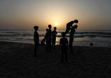شاب فلسطيني يلعب الباركور على شاطئ بحر مدينة غزة