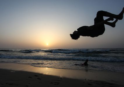 شاب فلسطيني يلعب الباركور على شاطئ بحر مدينة غزة