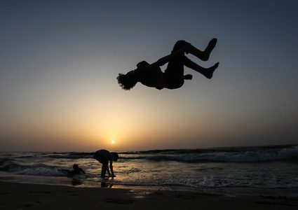 شاب فلسطيني يلعب الباركور على شاطئ بحر مدينة غزة