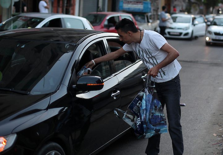 رجل مسيحي فلسطيني يوزع التمر والماء على المسلمين ، قبل الإفطار مباشرة في شهر رمضان المبارك ، في مدينة غزة