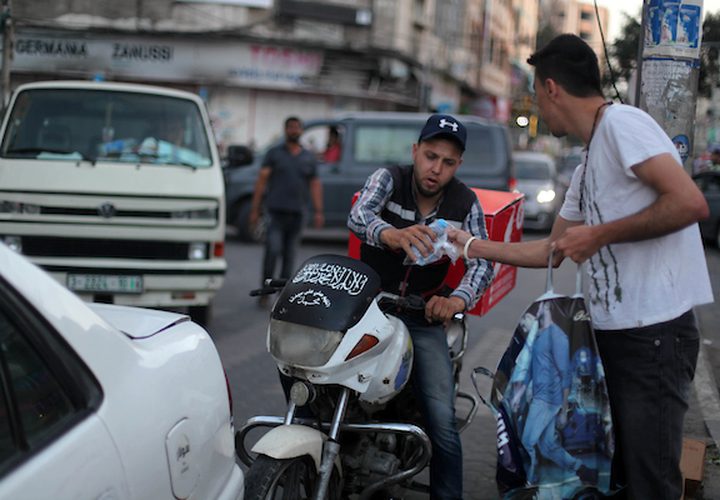 رجل مسيحي فلسطيني يوزع التمر والماء على المسلمين ، قبل الإفطار مباشرة في شهر رمضان المبارك ، في مدينة غزة