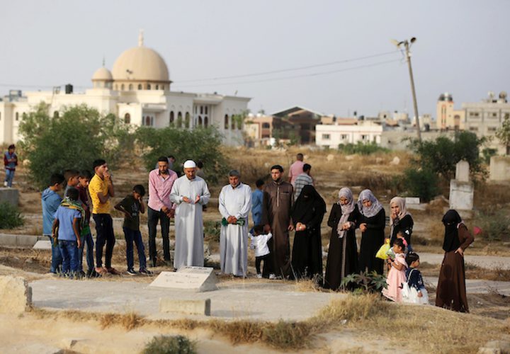 عدد من المواطنين في مدينة خانيونس جنوب القطاع ، يزورون المقابر في العيد  لقراءة الفاتحة لموتاهم.