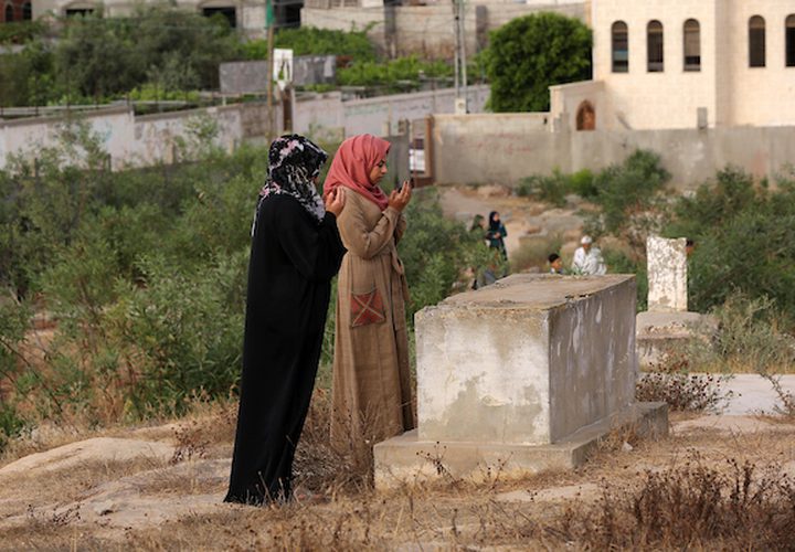 عدد من المواطنين في مدينة خانيونس جنوب القطاع ، يزورون المقابر في العيد  لقراءة الفاتحة لموتاهم.