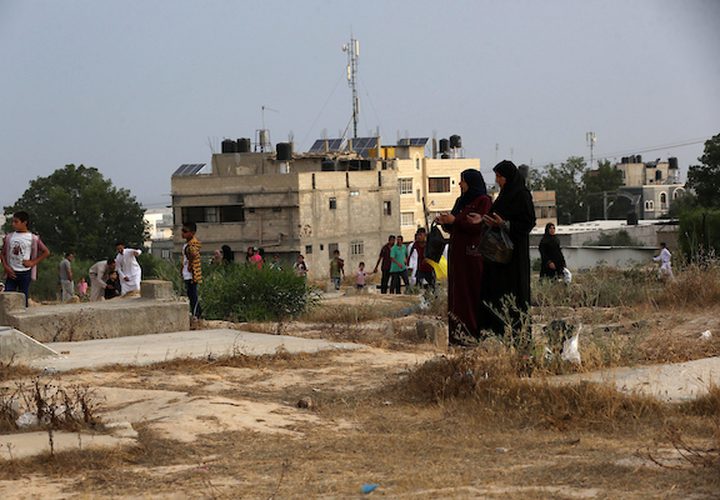 عدد من المواطنين في مدينة خانيونس جنوب القطاع ، يزورون المقابر في العيد  لقراءة الفاتحة لموتاهم.