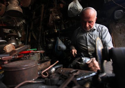 رجل فلسطيني ، أبو هاني المصعبي ، 68 عاماً ، يعمل على تصنيع وصيانة أدوات تقليدية من الكيروسين وأواني الطهي في متجره في مدينة غزة.