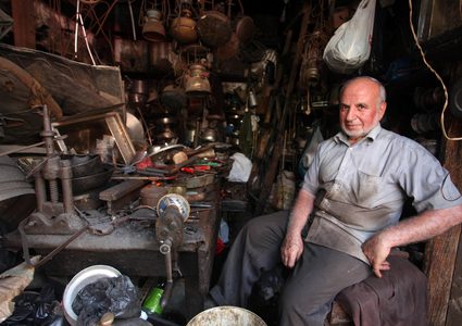 رجل فلسطيني ، أبو هاني المصعبي ، 68 عاماً ، يعمل على تصنيع وصيانة أدوات تقليدية من الكيروسين وأواني الطهي في متجره في مدينة غزة .