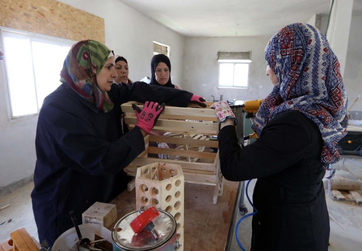 منتسبات المركز النسوي في قرية الولجة شمال غرب مدينة بيت لحم، يعملن على إعادة تدوير الأخشاب وتحويلها إلى تحف فنية أو مستلزمات للحدائق والبيوت