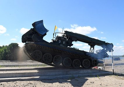 سائق ماهر يشغل جهاز "الآيفون" بجنزير جرافته