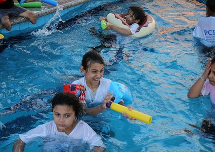 أطفال بترت أطرافهم يتعلمون السباحة خلال مخيم صيفي جنوب القطاع