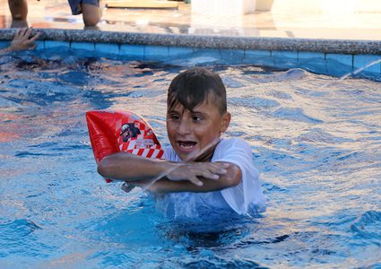 أطفال مبتورون يلعبون في حوض سباحة خلال معسكر صيفي ينظمه صندوق إغاثة الأطفال الفلسطينيين (PCRF) ، في خان يونس في جنوب قطاع غزة.