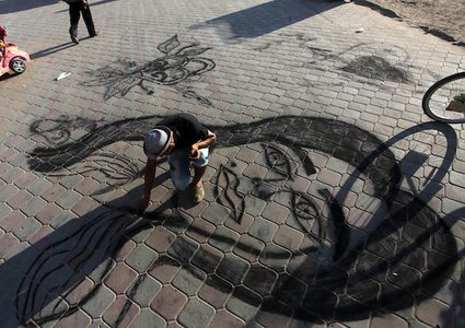 شاب غزي يبدع بالرسم بالفحم على الرصيف