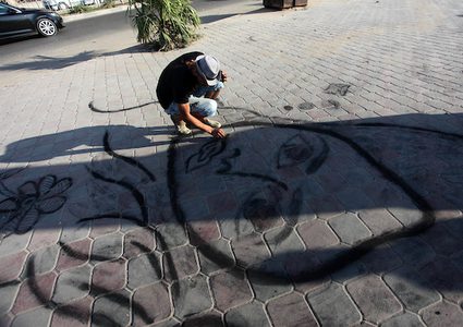 شاب غزي يبدع بالرسم بالفحم على الرصيف