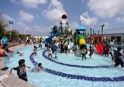 أطفال من غزة يستمتعون بالسباحة في بركة بإحدى منتجعات مدينة غزة السياحية