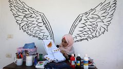 الفنانة الفلسطينية منال الاسطل 20 عاماً، ترسم على الملابس، في منزلها بخانيونس في قطاع غزة.