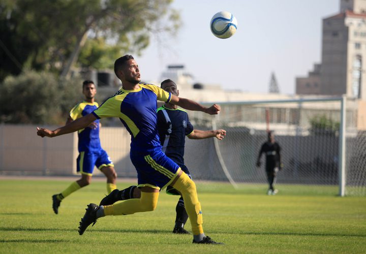 لاعبو كرة القدم من اتحاد بيت حانون والهلال يتنافسون في الدوري الممتاز على ملعب اليرموك في مدينة غزة.