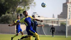 لاعبو كرة القدم من اتحاد بيت حانون والهلال يتنافسون في الدوري الممتاز على ملعب اليرموك في مدينة غزة.