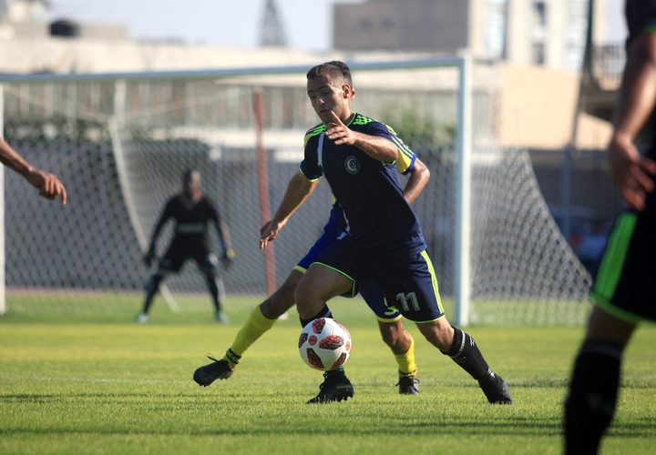 لاعبو كرة القدم من اتحاد بيت حانون والهلال يتنافسون في الدوري الممتاز على ملعب اليرموك في مدينة غزة.