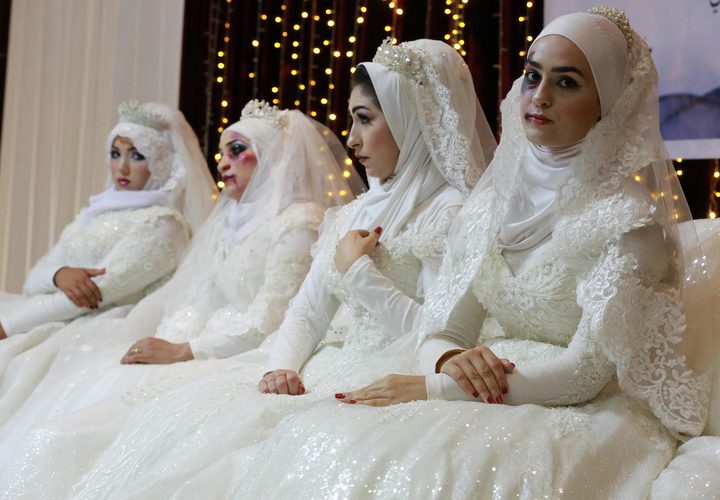 نساء فلسطينيات يرتدين فستان الزفاف ويشاركن في حدث مناهض للعنف ضد المرأة في غزة.