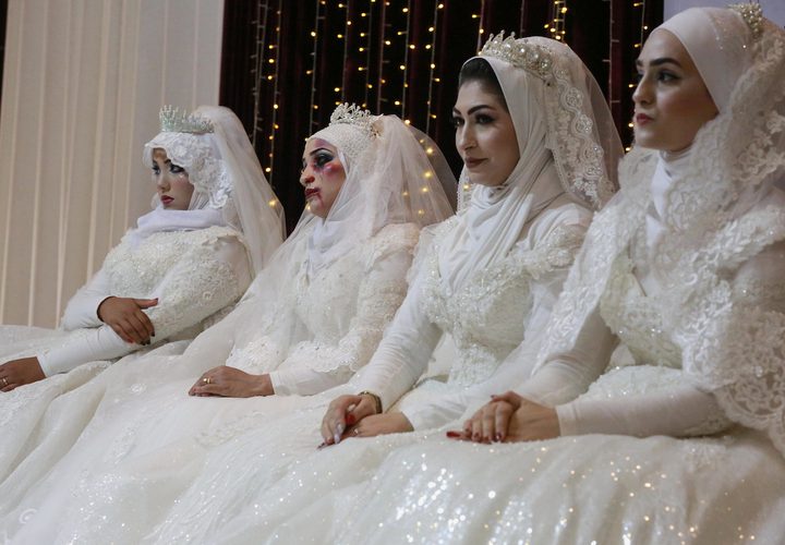 نساء فلسطينيات يرتدين فستان الزفاف ويشاركن في حدث مناهض للعنف ضد المرأة في غزة.
