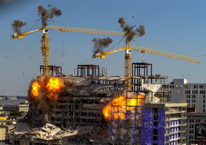 لحظة تفجير رافعتين ملاصقتين لفندق منهار